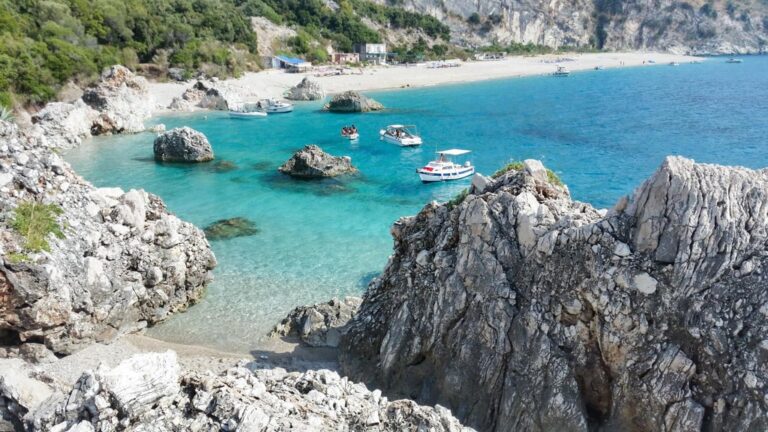 Rocky cliffs overlook the turquoise water and sandy shore of Krorëz beach in Albania